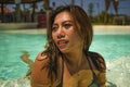Young beautiful and happy Asian Indonesian woman in bikini swimming in tropical island pool resort enjoying luxury and exotic Royalty Free Stock Photo