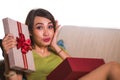 Young beautiful and happy Asian Indonesian woman holding birthday or Christmas present opening the gift box cheerful and excited Royalty Free Stock Photo