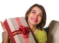 Young beautiful and happy Asian Indonesian woman holding birthday or Christmas present showing the gift box cheerful and excited Royalty Free Stock Photo