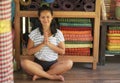 Young beautiful and happy Asian Indonesian woman sitting on wood floor in lotus pose smiling at yoga studio relaxed and zen like Royalty Free Stock Photo