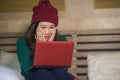 Young beautiful and happy Asian Japanese girl in winter beamy sitting relaxed on bed using laptop computer having fun enjoying onl Royalty Free Stock Photo