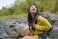 Young beautiful and happy Asian Japanese woman carrying backpack trekking on mountains crossing river enjoying holiday nature and Royalty Free Stock Photo