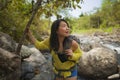Young beautiful and happy Asian Japanese woman carrying backpack trekking on mountains crossing river enjoying holiday nature and Royalty Free Stock Photo