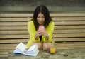 Lifestyle outdoors urban portrait of young attractive and beautiful Asian Japanese woman enjoying using internet social media app Royalty Free Stock Photo