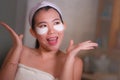 Young beautiful and happy Asian Japanese woman smiling to bathroom mirror applying hydrating eye patches under the eyes in beauty Royalty Free Stock Photo