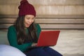 Young beautiful and happy Asian Korean girl in winter beamy sitting relaxed on bed using laptop computer having fun enjoying onlin Royalty Free Stock Photo