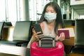 Young beautiful and happy Asian Korean tourist woman holding suitcase smiling cheerful and excited waiting at airport terminal Royalty Free Stock Photo