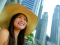 Young beautiful and happy Asian Korean tourist woman in Summer hat luxury at hotel infinity pool enjoying city buildings view chee Royalty Free Stock Photo