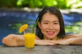 Young beautiful and happy Asian Korean woman in bikini enjoying Summer holiday at swimming pool relaxed and cheerful refreshing