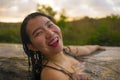 Young beautiful and happy Asian Korean woman in bikini enjoying sunset taking selfie at amazing jungle resort infinity pool Royalty Free Stock Photo