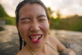 Young beautiful and happy Asian Korean woman in bikini enjoying sunset taking selfie at amazing jungle resort infinity pool Royalty Free Stock Photo