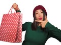 Young beautiful and happy Asian Korean woman in cool winter hat holding shopping bag excited buying Christmas present smiling in Royalty Free Stock Photo