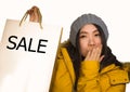 Young beautiful and happy Asian Korean woman in cool winter hat holding shopping bag excited buying Christmas present smiling Royalty Free Stock Photo