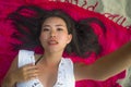 Young beautiful and happy Asian Korean woman lying flat on sarong on beach sand smiling cheerful and relaxed taking selfie Royalty Free Stock Photo