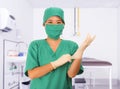 Young beautiful and happy Asian medicine doctor or chief hospital nurse in green scrubs and surgey hat and mask putting  latex Royalty Free Stock Photo