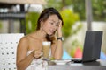 Beautiful happy woman in Summer dress outdoors at nice coffee shop having breakfast networking or working with laptop computer Royalty Free Stock Photo