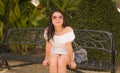 Young beautiful and happy Asian woman on park bench - lifestyle portrait of Attractive Japanese girl in Summer dress resting Royalty Free Stock Photo