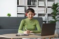 Young beautiful Happy Asian woman using laptop taking notes at home Royalty Free Stock Photo