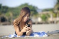 Beautiful and happy Asian woman using mobile phone texting on internet social media smiling relaxed Royalty Free Stock Photo