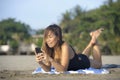 Beautiful and happy Asian woman using mobile phone texting on internet social media smiling relaxed Royalty Free Stock Photo