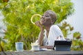 Young beautiful and happy black African American woman enjoying outdoors at cafe working with digital tablet listening to music wi Royalty Free Stock Photo