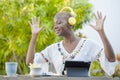 Young beautiful and happy black African American woman enjoying outdoors at cafe working with digital tablet listening to music wi Royalty Free Stock Photo