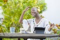 Young beautiful and happy black African American woman enjoying outdoors at cafe working with digital tablet listening to music wi Royalty Free Stock Photo