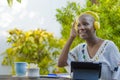 Young beautiful and happy black African American woman enjoying outdoors at cafe working with digital tablet listening to music wi Royalty Free Stock Photo