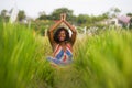Young beautiful and happy black African American woman sitting at rive field outdoors practicing yoga relaxation and meditation Royalty Free Stock Photo