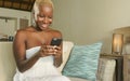 Young beautiful and happy black African American woman smiling excited using internet social media app on mobile phone networking Royalty Free Stock Photo