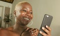 Young beautiful and happy black African American woman smiling excited using internet social media app on mobile phone networking Royalty Free Stock Photo