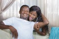 Young beautiful and happy black afro American couple in love relaxed at modern home living room cuddling sweet on sofa couch Royalty Free Stock Photo