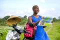 Young beautiful and happy black afro american tourist woman with scooter motorbike looking to road map searching destination explo Royalty Free Stock Photo