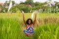 Young beautiful and happy black afro American woman sitting at rive field outdoors practicing yoga relaxation and meditation Royalty Free Stock Photo