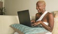 Young beautiful and happy black afro American woman smiling excited having fun on internet using social media on laptop computer Royalty Free Stock Photo