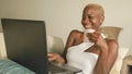 Young beautiful and happy black afro American woman smiling excited having fun on internet using social media on laptop computer