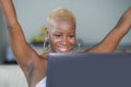 Young beautiful happy black afro American woman smiling working on laptop computer at home relaxed on sofa couch celebrating succe Royalty Free Stock Photo