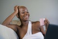 Young beautiful happy black afro American woman smiling working on laptop computer at home relaxed on sofa couch in internet onlin