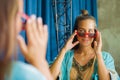 Young beautiful and happy blond woman enjoying shopping trying out clothes and sunglasses in the mirror at vintage and cool beauty Royalty Free Stock Photo