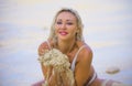 Young beautiful and happy blond woman in white bikini playing with sand cheerful and carefree isolated on tropical paradise desert Royalty Free Stock Photo