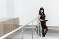 Young Beautiful happy brunette woman dressed in a black business suit working with a notebook, standing in office, smiling Royalty Free Stock Photo