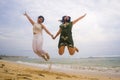 Young beautiful and happy couple of attractive Asian Chinese women jumping on the air together at the beach enjoying holidays Royalty Free Stock Photo