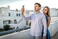 Young beautiful happy couple bloggers, smiling making selfie, online broadcasting, posing, communicate. Guy holds mobile Royalty Free Stock Photo