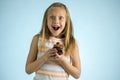 Young beautiful happy and excited blond girl 8 or 9 years old holding chocolate cake on her hand looking spastic and cheerful in s Royalty Free Stock Photo