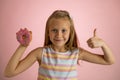 Young beautiful happy and excited blond girl 8 or 9 years old holding donut desert on her hand looking spastic and cheerful in sug