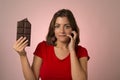 Young beautiful happy and excited woman holding big chocolate bar in sugar addiction temptation