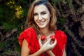 Young beautiful happy funny girl with red dress and makeup holding strawberry in summertime in the park. Royalty Free Stock Photo