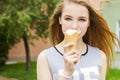 Young beautiful happy girl with long hair in a Sunny day walking around the city and eat ice cream Royalty Free Stock Photo