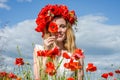 Young beautiful happy girl with long hair in a white dress in the poppy field with a wreath on his head Royalty Free Stock Photo