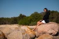 Young beautiful happy latin girl outside on rocky beach Royalty Free Stock Photo